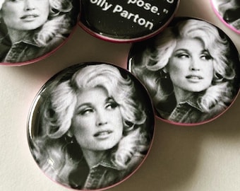 May include: A collection of round buttons featuring a black and white image of Dolly Parton. One button has the quote "Find out who you are and do it on purpose." in white text. The buttons have a pink border.