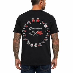 Peut inclure: Un t-shirt noir à manches courtes avec un motif circulaire au dos. Le design affiche le mot Carvette en écriture blanche, entouré de divers petits emblèmes circulaires et d'icônes de drapeaux à damier, chacun marqué d'une année précise.