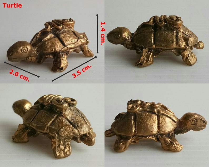 Może przedstawiać: Brązowa figurka ż&oacute;łwia o długości 3,5 cm, szerokości 2,0 cm i wysokości 1,4 cm. Ż&oacute;łw ma szczeg&oacute;łowy pancerz i głowę, z małym elementem dekoracyjnym na grzbiecie. Słowo "Turtle" znajduje się w lewym g&oacute;rnym rogu.