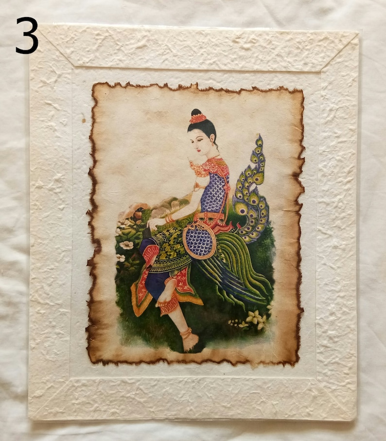 May include: A framed painting of a woman in a colorful dress sitting on a peacock. The painting is on a textured paper background.