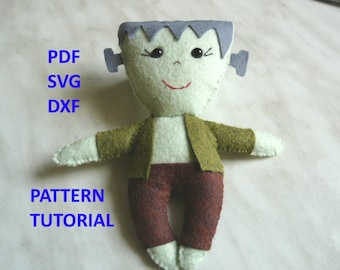 May include: A handmade felt Frankenstein's monster doll with a green jacket, brown pants, and gray hair. The doll has black button eyes and a red stitched smile. Text on the left side reads "PDF SVG DXF PATTERN TUTORIAL".