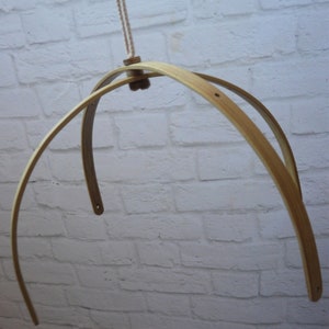 May include: A wooden baby mobile hanging frame with two hoops, made of natural wood, with a white string hanging from the top.