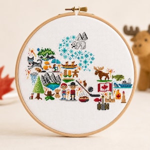 Peut inclure: Un cercle à broder en point de croix représentant une carte du Canada ornée de symboles culturels canadiens. Le motif comprend un orignal, une feuille d'érable et des éléments de hockey. Le cercle est en bois, environ 20 cm de diamètre.