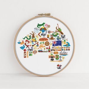 Op de afbeelding: Een witte borduurring met een kleurrijk kruissteekontwerp van het Australische continent. Het ontwerp bevat verschillende iconen die de Australische cultuur vertegenwoordigen, zoals kangoeroes, koala's, boomerangs en de Australische vlag.