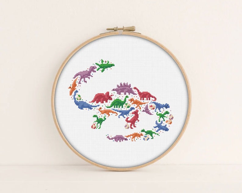 May include: A cross-stitch pattern of a dinosaur-shaped design with multiple colourful dinosaurs, including green, blue, orange, purple and red.