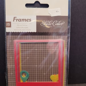 May include: A pack of 15 die-cut frames in a clear plastic sleeve. The frames are red, yellow, and green, with a heart and location pin design. The package includes the text "Frames" and "Studio Calico".