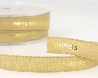May include: Gold ribbon with the text "merry christmas" printed in gold foil. The ribbon is wound around a spool.