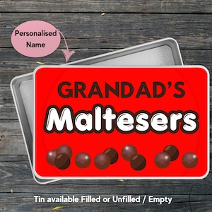 May include: A rectangular metal tin with a bright red lid featuring the text "GRANDAD'S Maltesers" in dark brown and white lettering. The lid is decorated with illustrations of small brown spherical candies along the bottom edge.