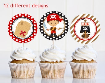 Op de afbeelding: Drie cupcakes versierd met cupcake-toppers met een piraten thema. De toppers tonen een schatkaarten, een piraat met een zwaard en een piratenschip met een schedel en gekruiste botten.