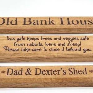 May include: Three rectangular wooden signs with beveled edges and pre-drilled holes. The top sign reads Old Bank House. The middle sign reads This gate keeps trees and veggies safe from rabbits, hens and sheep! Please take care to close it behind you. The bottom sign reads Dad & Dexter's Shed.