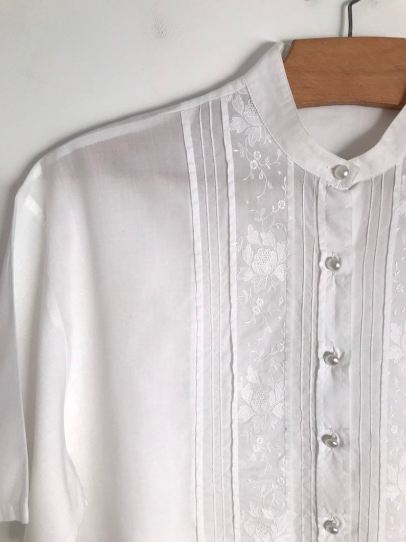 Vintage white embroidered short sleeve button down pin tuck tunic blouse with floral patterns and mock neck collar s m 1970s