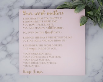 May include: Pink motivational poster with gold text that reads "Your work matters. Everyday that you show up, even when it's hard and you don't feel like it, you are making a difference. So, even on the hard days - even on the days where you'd like to stay home and not show up - remember: The world needs the magic inside of you. Your work matters. Your consistency matters. Your ideas matter. Your presence matters. You matter. Keep it up."