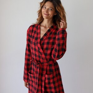 May include: A red and black buffalo plaid robe with a tie belt and pockets.