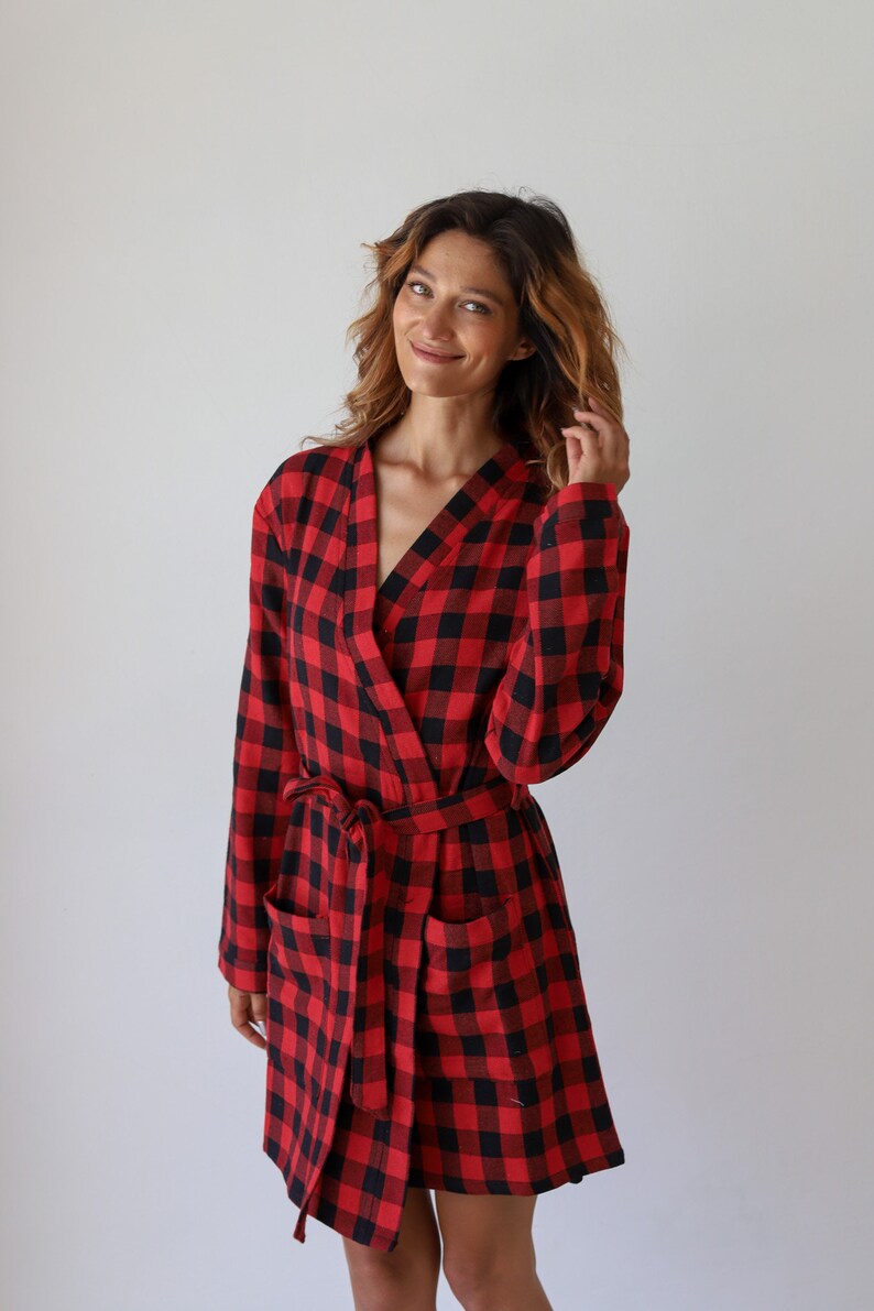 May include: A red and black buffalo plaid robe with a tie belt and pockets.