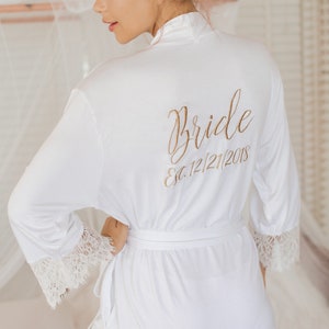 May include: White satin robe with lace trim and the words "Bride Est. 12/21/2018" embroidered on the back.