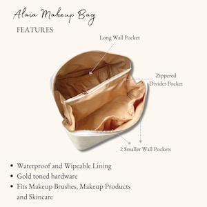 May include: White makeup bag with gold toned hardware. The bag has a zippered divider pocket, a long wall pocket, and two smaller wall pockets. The bag is lined with waterproof and wipeable material.