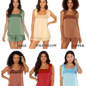 Peut inclure: Pr&eacute;sentation de six ensembles de pyjamas cami &agrave; n&oelig;uds en satin, disponibles en vert sauge, jaune p&acirc;le, cuivre, auburn, rouge et bleu ciel. Chaque ensemble comprend un haut cami &agrave; bretelles nou&eacute;es et un short assorti. L'image pr&eacute;sente les options de couleurs.