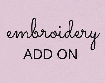 May include: A light pink background featuring the word embroidery in a black cursive script font, positioned above the word ADD ON written in a bold, black, uppercase sans-serif typeface. The overall design is clean and simple.