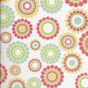 May include: A white background with a repeating pattern of colorful circles. The circles are made up of smaller circles in shades of pink, yellow, green, and blue.