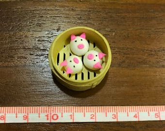 Bamboo steamer and three piggy buns