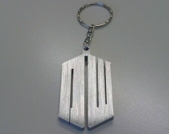 May include: A silver metal keychain featuring a stylised image of the TARDIS, the time-traveling police box from the Doctor Who television series.