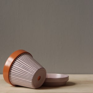 May include: White ceramic mug with a black handle, featuring the text "But First, Coffee" in black. The mug is displayed against a blurred backdrop, implying a comfortable environment.