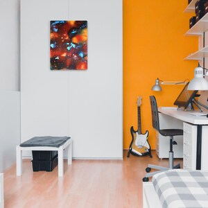 Pu&ograve; includere: Una scrivania bianca con una sedia bianca e un monitor per computer. C'&egrave; una chitarra appoggiata alla scrivania e un dipinto sul muro dietro la scrivania.