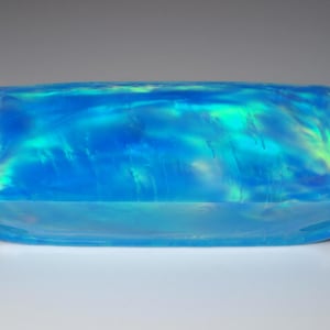 Peut inclure: Une pierre précieuse rectangulaire en opale bleue avec des reflets irisés de vert et de jaune.