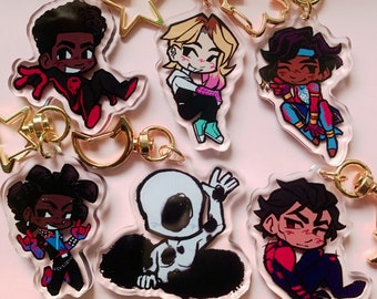 May include: Set of eight colorful cartoon character keychains. The keychains are made of clear acrylic and feature different characters with various poses and expressions. The characters are all wearing different outfits and accessories.