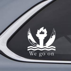 May include: White vinyl car sticker with a stylized torch design and the text "We go on".