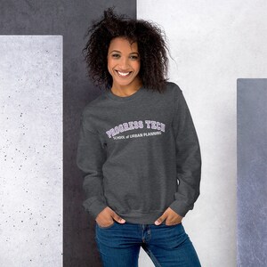 Puede incluir: Una sudadera gris antracita con un gráfico arqueado morado y blanco que dice "Progress Tech School of Urban Planning".