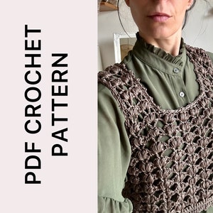 Può includere: Uno schema a uncinetto PDF per un gilet all'uncinetto marrone. Il gilet ha un delicato disegno traforato e una scollatura rotonda.