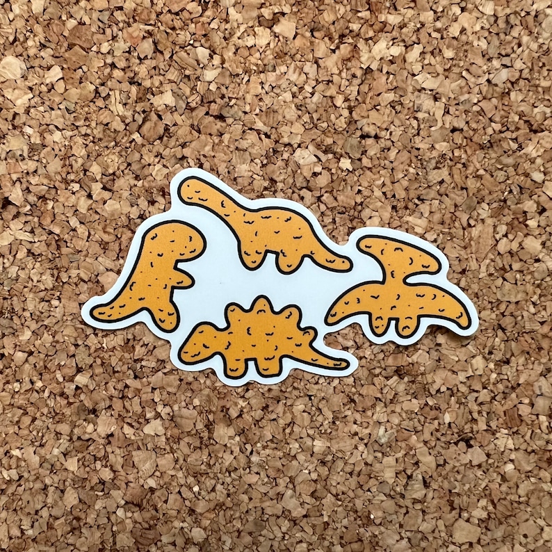 May include: Four yellowish tan dinosaur  nugget stickers on a corkboard background. The dinosaurs are in various poses. The stickers are made of a vinyl material