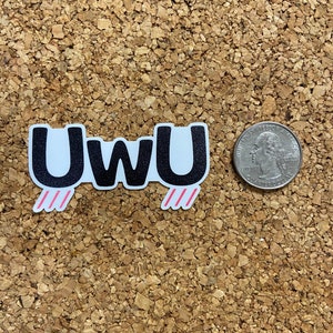 May include: A black and white sticker with the word "UwU" in bold black letters. The sticker has pink diagonal lines on either side of the word.