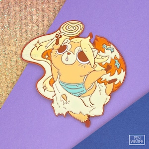 May include: A yellow and orange enamel pin featuring a cartoon raccoon holding a lollipop. The raccoon is wearing a blue and white striped swimsuit and a white dress. The pin has a sparkly background and the text "PEN WINTER" is visible in the bottom right corner.