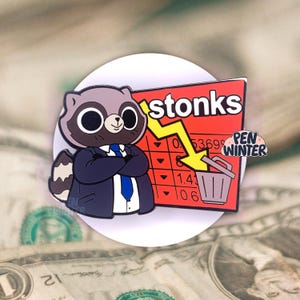 Puede incluir: Un pin de esmalte con un mapache de dibujos animados que lleva un traje azul y una corbata, de pie frente a una tabla roja con la palabra "stonks" y una flecha amarilla hacia abajo. La tabla muestra una serie de números, incluyendo 0.53699, 1.41 y 1.06. El pin también incluye un pequeño icono de cubo de basura.