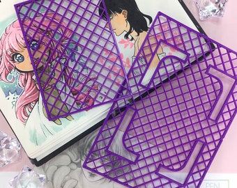 May include: Two purple plastic grid drawing stencils, one is a square and the other is a rectangle with a cut-out shape. The stencils are on top of a sketchbook with a drawing of two anime characters.