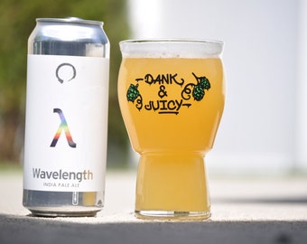 Może przedstawiać: Puszkę piwa India Pale Ale Wavelength obok szklanki piwa z napisem "Dank & Juicy".