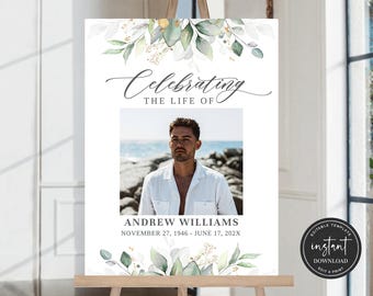 Op de afbeelding: Een wit bord met een groen en wit bloemenontwerp boven en onder. Het bord zegt "Celebrating the life of" en heeft een foto van een man in het midden. De tekst onder de foto zegt "Andrew Williams 27 november 1946 - 17 juni 202X".