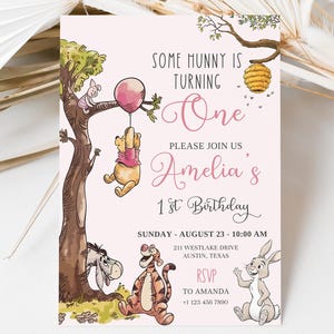 K&ouml;nnte beinhalten: Eine rosa Geburtstagseinladung mit Illustrationen von Winnie Puuh und seinen Freunden. Der Einladungstext lautet "Some Hunny is Turning One" und "Amelia's 1st Birthday". Das Bild zeigt Puuh an einem Ballon h&auml;ngend.