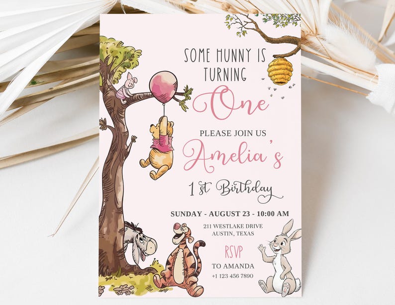 K&ouml;nnte beinhalten: Eine rosa Geburtstagseinladung mit Illustrationen von Winnie Puuh und seinen Freunden. Der Einladungstext lautet "Some Hunny is Turning One" und "Amelia's 1st Birthday". Das Bild zeigt Puuh an einem Ballon h&auml;ngend.