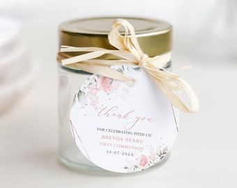 Pode incluir: Uma etiqueta redonda branca de agradecimento com um design floral e detalhes dourados. A etiqueta diz "obrigado" e "por celebrar conosco! Brenda Henry, Primeira Comunhão, 15-07-2023".