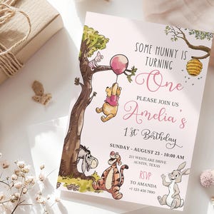 K&ouml;nnte beinhalten: Eine rosa Einladung zum ersten Geburtstag. Die Einladung zeigt Illustrationen von Winnie-the-Pooh-Charakteren, darunter Puuh, Ferkel, Tiger, I-Aah und Rabbit. Der Text lautet "Some Hunny is Turning One" und l&auml;dt die G&auml;ste zu Amelias 1. Geburtstag ein.