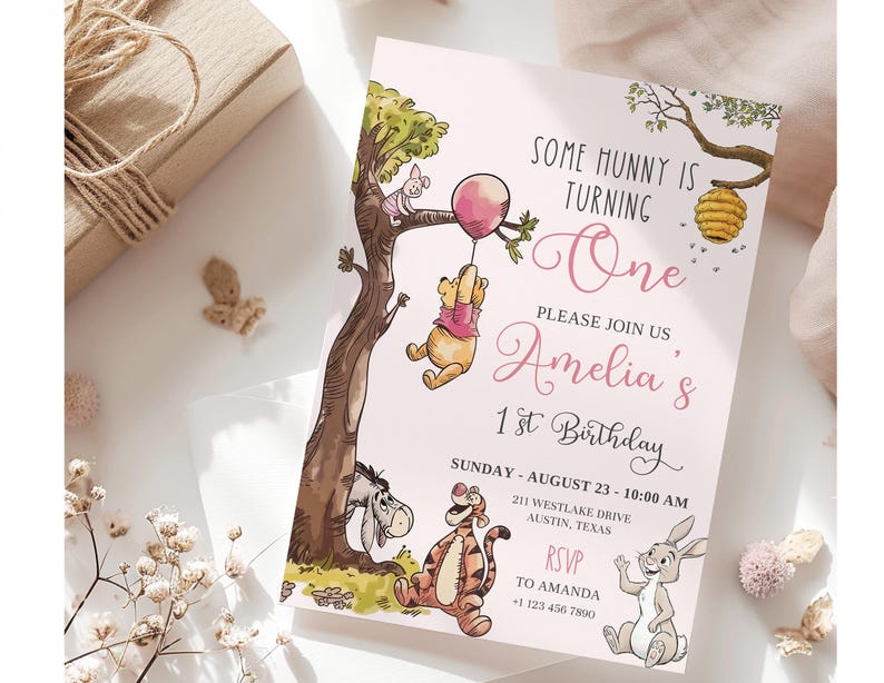 K&ouml;nnte beinhalten: Eine rosa Einladung zum ersten Geburtstag. Die Einladung zeigt Illustrationen von Winnie-the-Pooh-Charakteren, darunter Puuh, Ferkel, Tiger, I-Aah und Rabbit. Der Text lautet "Some Hunny is Turning One" und l&auml;dt die G&auml;ste zu Amelias 1. Geburtstag ein.