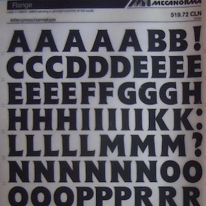 May include: A black and white image of a font chart with the letters A through Z, numbers 0 through 9, and various symbols. The font is a bold, sans-serif typeface.