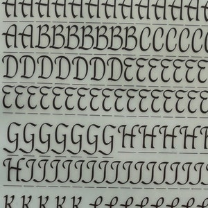 Puede incluir: Una hoja de letras de transferencia de fuente Letragraphica, un producto de Letraset International Ltd. La hoja presenta un alfabeto completo en un estilo de escritura cursiva, junto con números, signos de puntuación y símbolos. La hoja está etiquetada como "Letragraphica" y "LG3709" e incluye el texto "Protected widely by patents and patent applications".