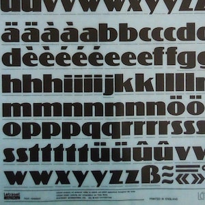 May include: A sheet of Letragraphica font samples in black on a light blue background. The font is 72pt and 18.8mm. The font is called Koloss and is for photosetting. The sheet is labelled LG1831.