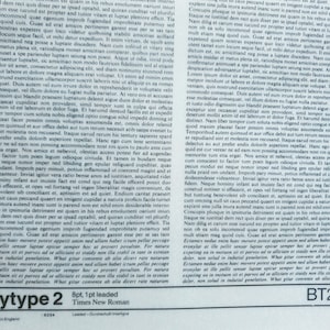 May include: A printed page with dense text, featuring the words "Bodytype 2" and "Times New Roman" at the bottom. The page has a vintage aesthetic, with a faded appearance and a "BT2-100" marking.