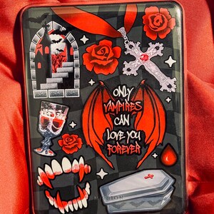 Könnte beinhalten: Schwarze und graue Handyhülle mit einem gotischen Vampir-Thema. Mit roten Rosen, einem Kreuzanhänger, Vampirzähnen und dem Text "ONLY VAMPIRES CAN LOVE YOU FOREVER". Enthält einen Sarg und eine Burg-Illustration.
