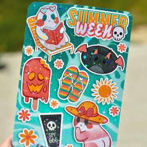 May include: A teal sticker sheet with summer-themed illustrations. Includes a ghost reading a book, a bat, a popsicle, flip-flops, a sun, a ghost in a hat, and SPF 666 sunscreen. The words "SUMMER WEEK" are at the top.